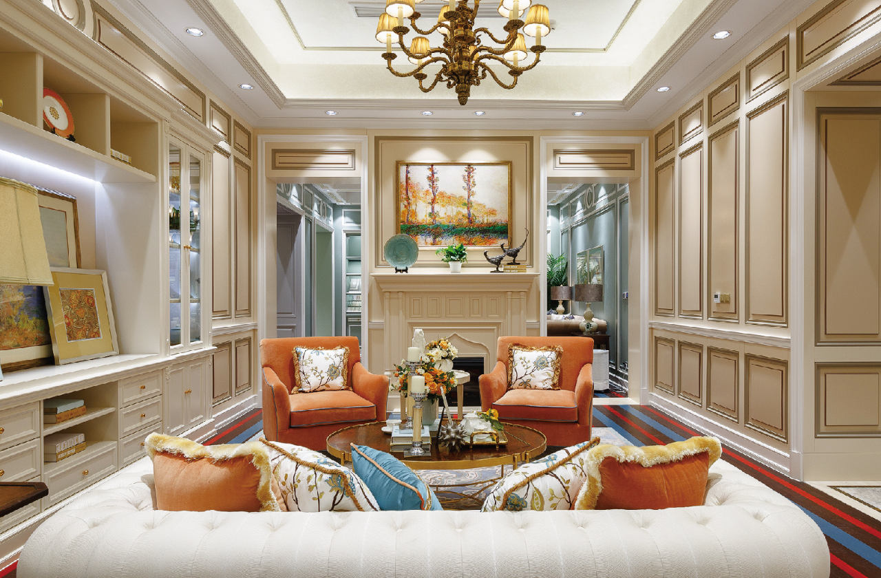 Luxurious living room with orange armchairs, white sofa, and decorative elements.