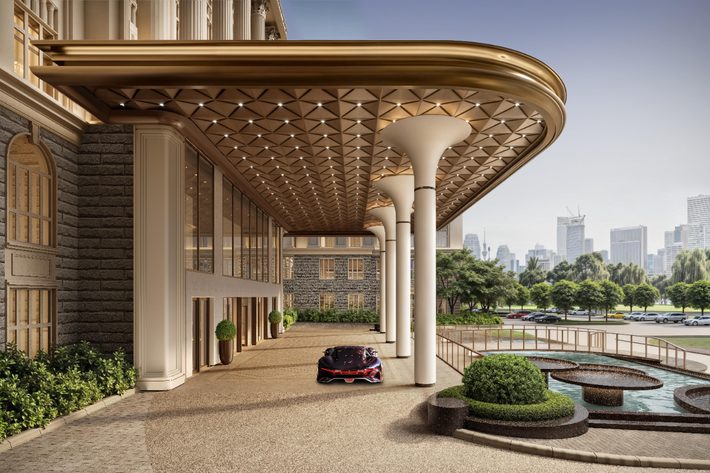 Luxurious building entrance with a car parked in front, city skyline in the background