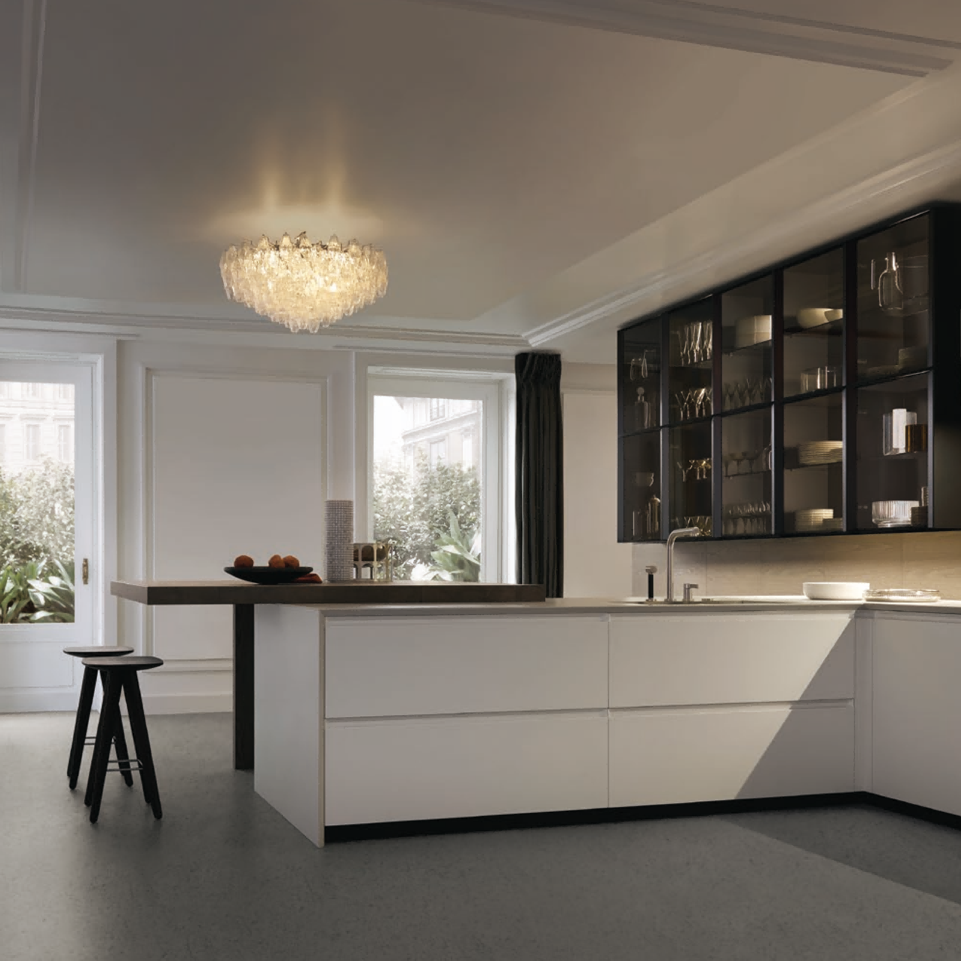 Modern kitchen with white cabinets, black accents, and a chandelier.